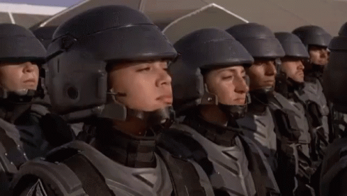 Gif from the Starship Troopers scene of a woman in uniform turning to the camera with the caption 'I'M DOING MY PART' at the bottom.